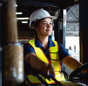 Female construction working smiling and driving a crane truck